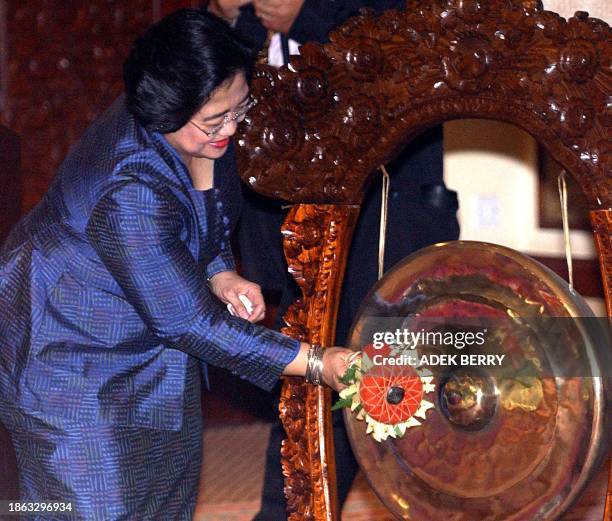 Indonesian President Megawati Sukarnoputri bangs a gong to mark the opening of the 5th Asia and Europe Foreign Ministers meeting in Denpasar, 24 July...