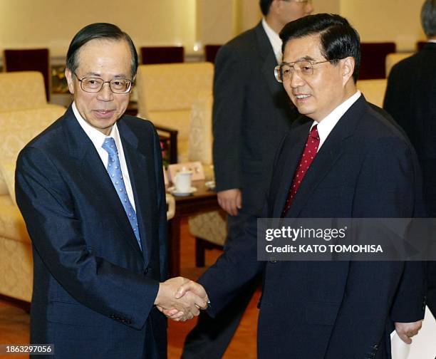 Japanese Chief Cabinet Secretary Yasuo Fukuda shakes hands with Chinese President Hu Jintao at the Great Hall of the People in Beijing 09 August 2003...