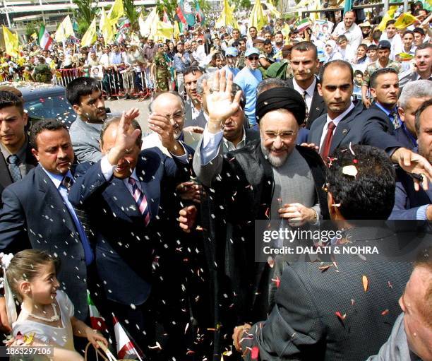 Iranian President Mohammad Khatami , accompanied by his Lebanese counterpart Emile lahoud, waves for a crowd gathered to salute him upon his arrival...