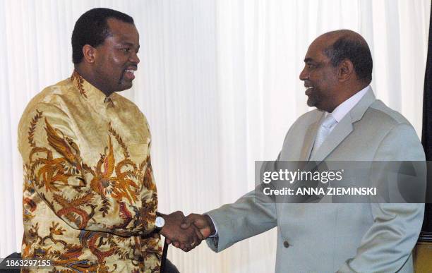 Sudan President Omar Hassan Ahmad Al-Bashir shakes hands with Swazi King Mswati III after a bilateral meeting on the side-lines of the 2003 Smart...