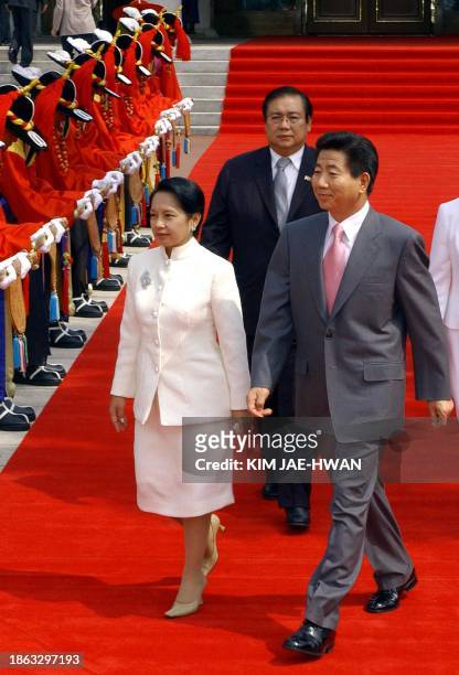 South Korean President Roh Moo-Hyun and Philippine President Gloria Arroyo walk pass honor guard at the Blue House in Seoul, 03 June 2003. Arroyo is...