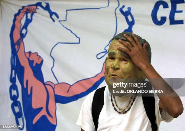 Political activist wearing a George W. Bush mask, particiaptes in a march in front of the US embassy in Guatemala City 15 March 2003, in protest to...