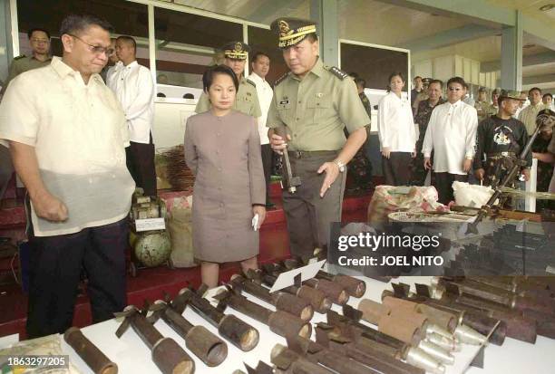 President Gloria Arroyo , accompanied by Defense Secretary Angelo Reyes and military chief General Narciso Abaya , inspect explosive materials...