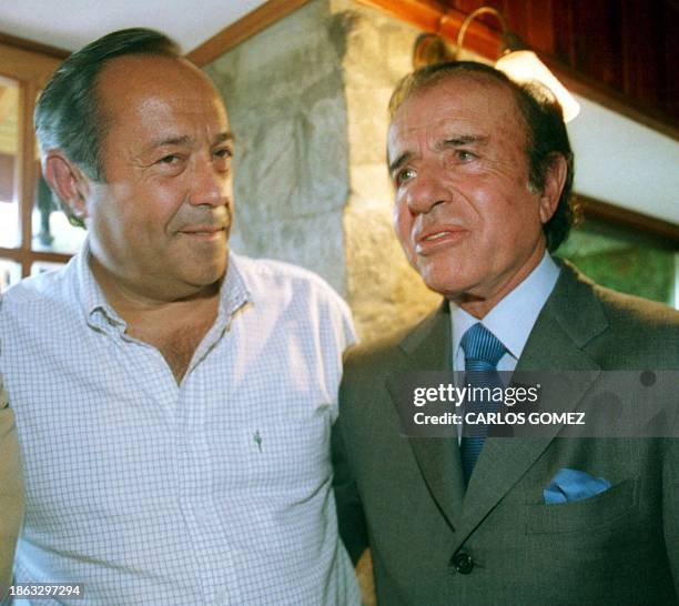 Former Argentine President and candidate for the upcoming presidential elections, Carlos Menem, speaks with Adolfo Rodriguez Saa, looser during the...