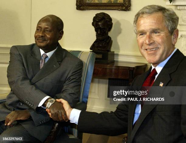 President George W. Bush and the Ugandan President Yoweri Museveni shake hands 10 June 2003 in the Oval Office of the White House in Washinton, DC....