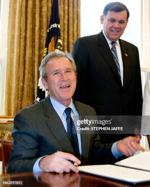 President George W. Bush laughs with Housing and Urban Development Secretary Mel Martinez in the Oval Office of the White House 15 April 2003 in...
