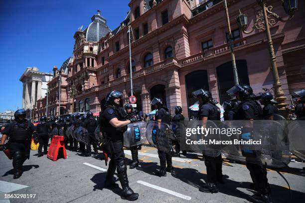 Police officers stand guard outside Constitucion train station before a demonstration against President Javier Milei and recent announcements by...