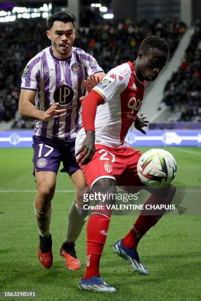 Monaco's Senegalese midfielder Krepin Diatta fights for the ball with Toulouse's Chilean defender Gabriel Suazo during the French L1 football match...