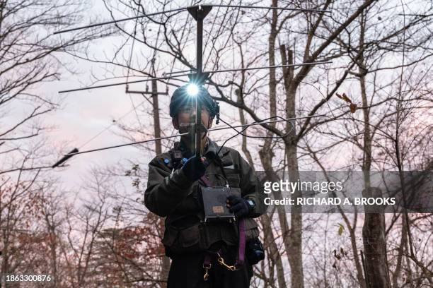 This photo taken early on November 10, 2023 shows Junpei Tanaka, a wildlife expert for the nonprofit organisation Picchio Wildlife Research Center,...