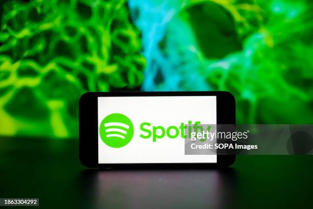 In this photo illustration, the Spotify logo is seen displayed on a mobile phone screen.