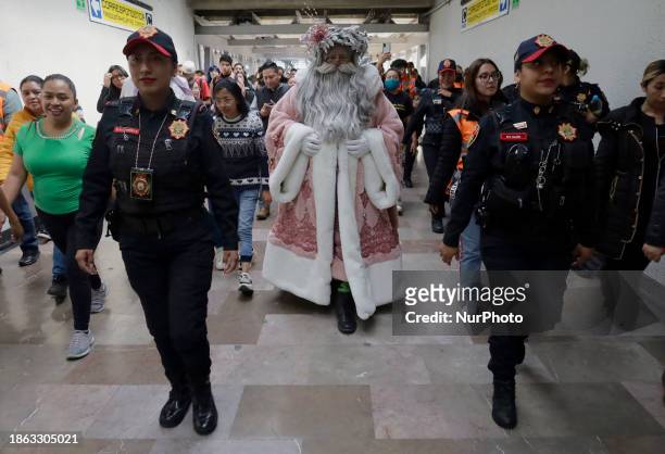 Jose Miguel Moctezuma Gonzalez, a street artist who specializes in human statues and makeup, is dressed as Father Christmas and is walking through...