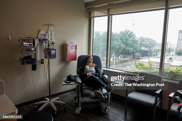 Emily Domhoff sits with a saline drip IV after having her chemo infusion pump removed at the Norton Cancer Center on June 7 in Louisville, KY....