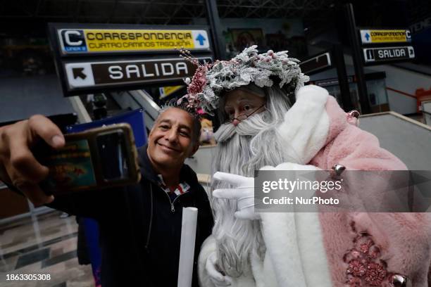 Jose Miguel Moctezuma Gonzalez, a street artist who specializes in human statues and make-up, is dressed as Father Christmas and is traveling around...