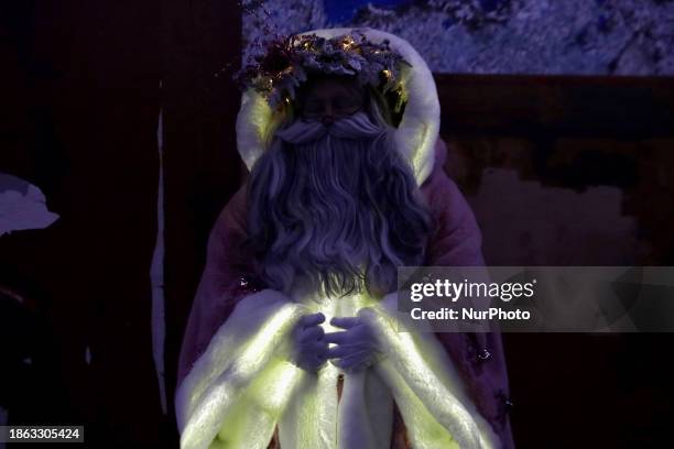 Jose Miguel Moctezuma Gonzalez, a street artist who specializes in human statues and make-up, is posing as Father Christmas and walking through...