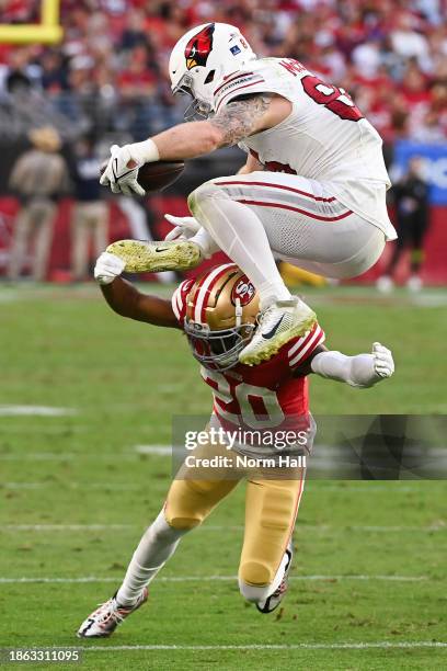 Trey McBride of the Arizona Cardinals jumps over Ambry Thomas of the San Francisco 49ers during the third quarter at State Farm Stadium on December...