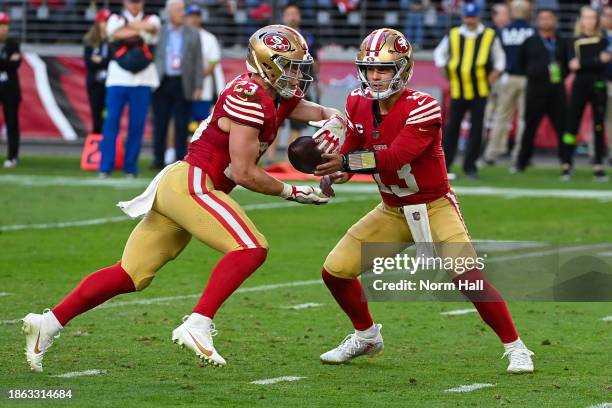 Brock Purdy of the San Francisco 49ers hands the ball off to Christian McCaffrey of the San Francisco 49ers during the fourth quarter against the...