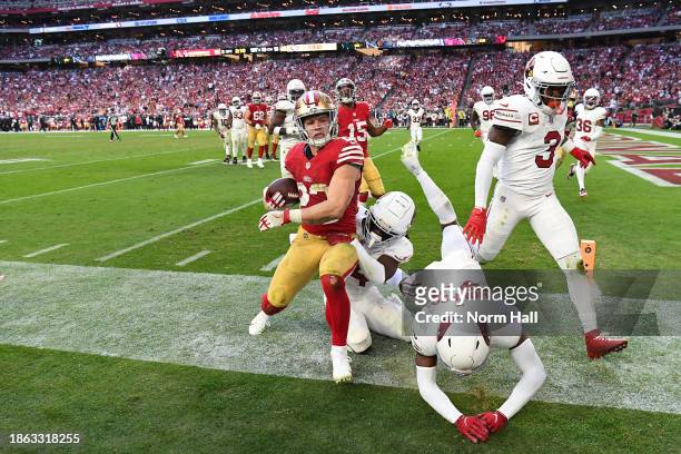 Christian McCaffrey of the San Francisco 49ers is forced out of bounds by a slew of Arizona Cardinals defenders during the fourth quarter at State...