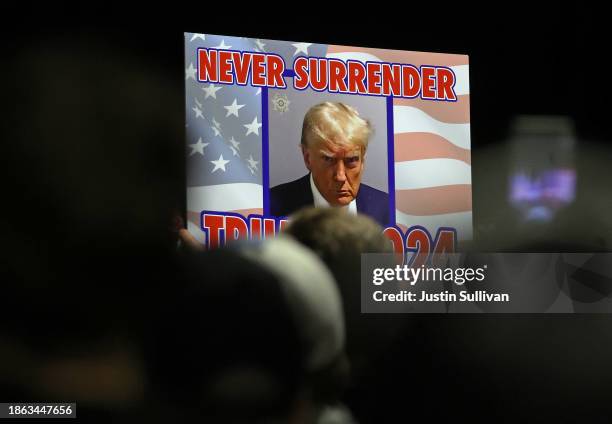 Supporters of Republican Presidential candidate former U.S. President Donald Trump hold a sign as he delivers remarks during a campaign rally at the...