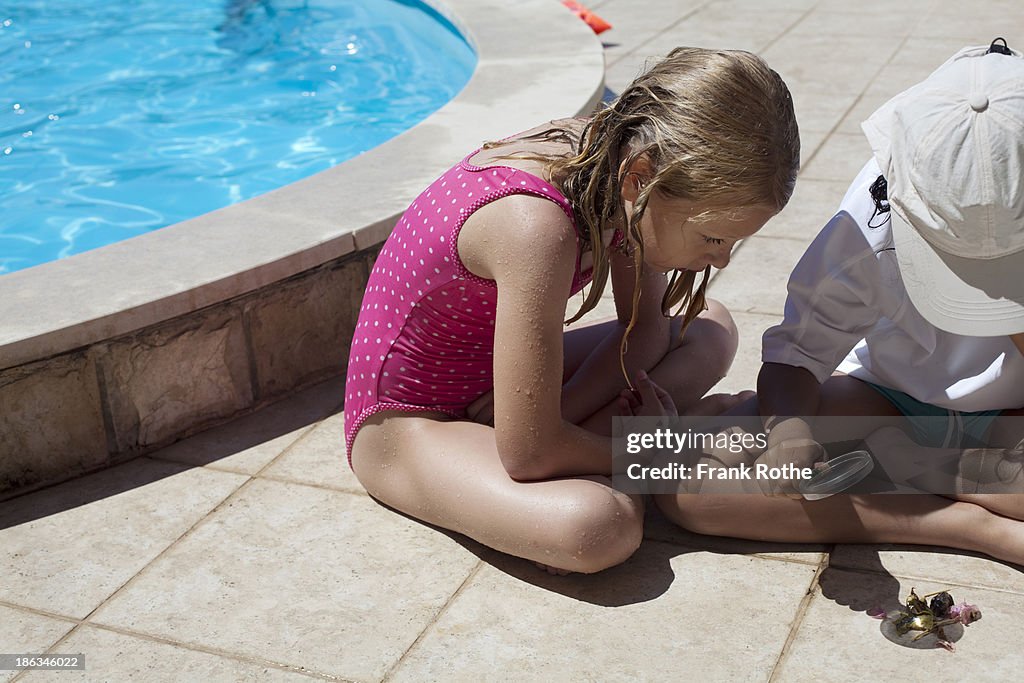 Children playing in the sun with a magnifying glas
