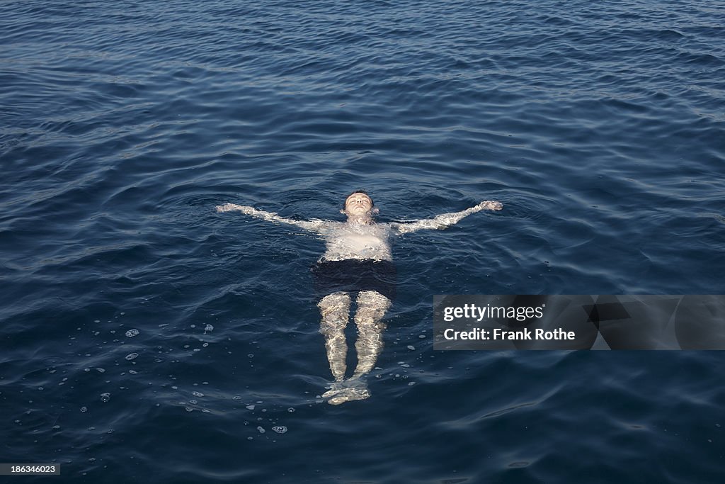 Man playing a dead man in the water