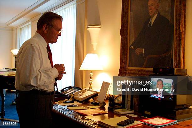 Secretary of Defense Donald Rumsfeld watches television as President George W. Bush announce attacks on terrorists in Afghanistan October 7, 2001 in...