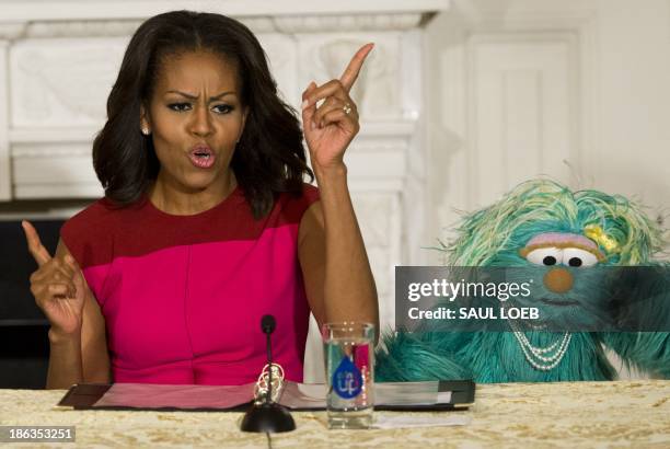 First Lady Michelle Obama dances alongside Sesame Street character Rosita during an event announcing free licensing of Sesame Street characters to...
