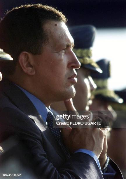 Venezuelan President Hugo Chavez listens to discussions during a function at the Military School of Aviation 19 May 2000 in Maracay, 100 kms west of...