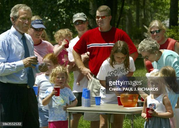 President George W. Bush stops for a lemonade at a roadside stand run by local firefighter Edward Dew and his family while motorcading to Raliegh...