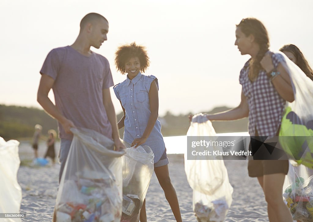 Group of people collecting trash on beach