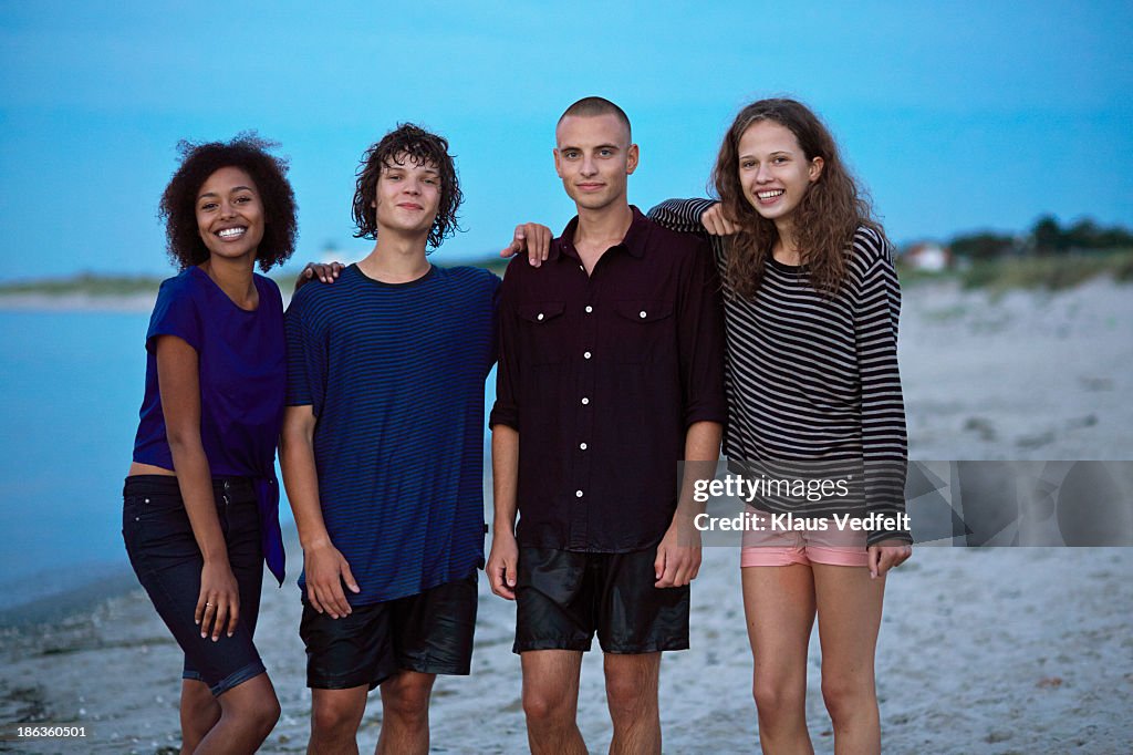 Teens standing together on beach after swim