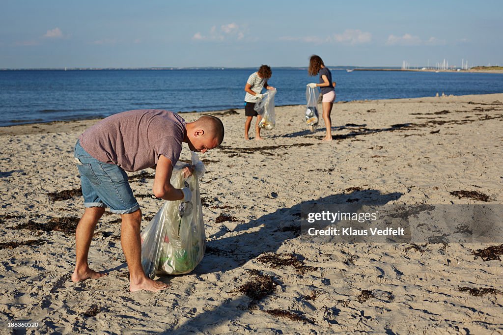 Group of people collecting trash on beach