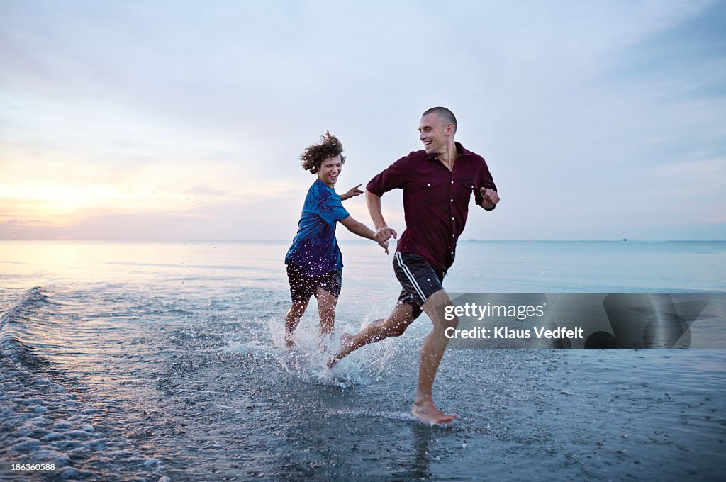 Young guys chasing each other in the ocean