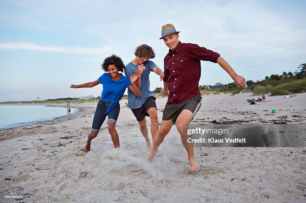 Young people doiing running competition on beach