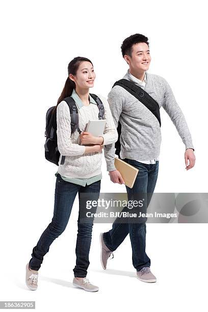 happy college couple walking side by side - college student holding books stockfoto's en -beelden