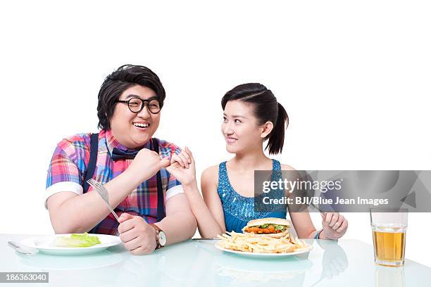 overweight young man and young woman making a finger oath on dieting - pinky promise stock pictures, royalty-free photos & images