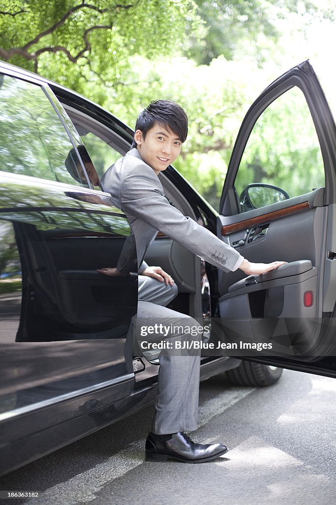 Businessman getting off car