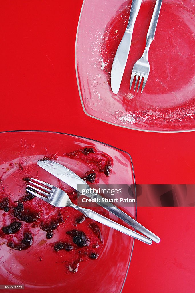 Two finished dessert plates on red table