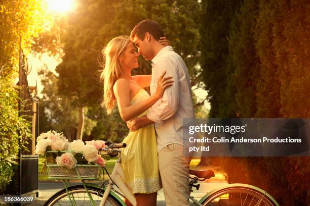 caucasian couple hugging on bicycle - couple in love stock pictures, royalty-free photos & images