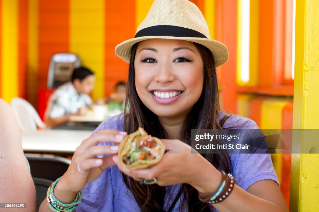 Asian woman eating in restaurant