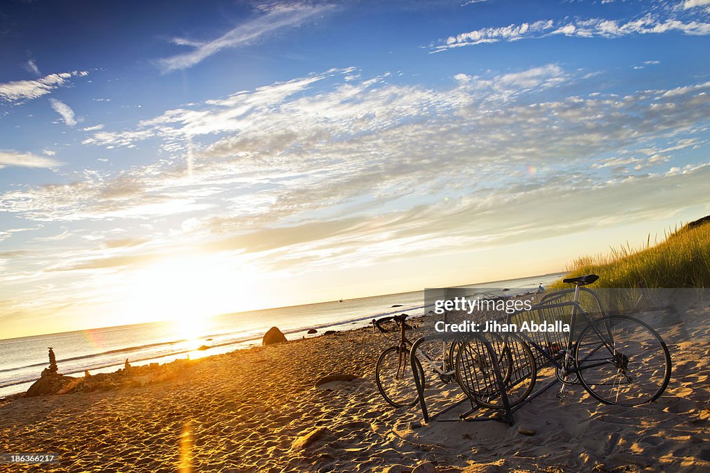 Bicycles parked on beach at sunset