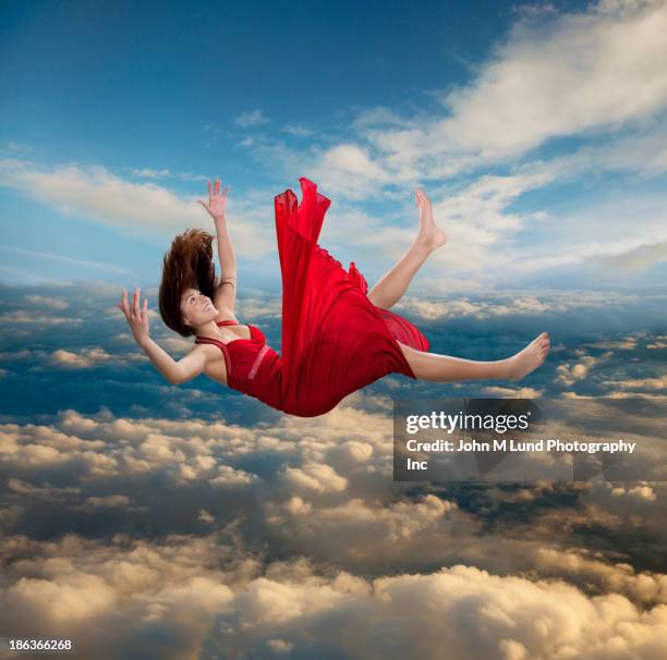 mixed race woman falling through clouds - horizontal falls stock pictures, royalty-free photos & images