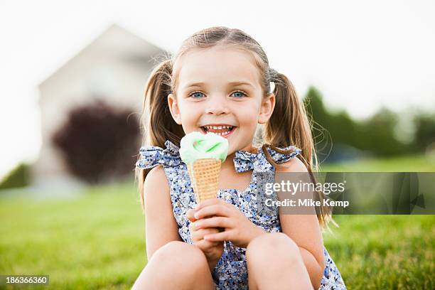 caucasian girl eating ice cream outdoors - girl eating messy ice cream cone stock pictures, royalty-free photos & images