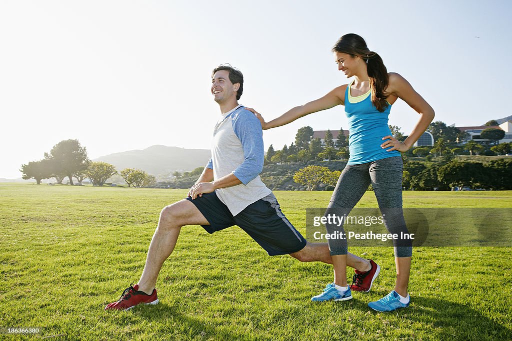 Couple stretching in park