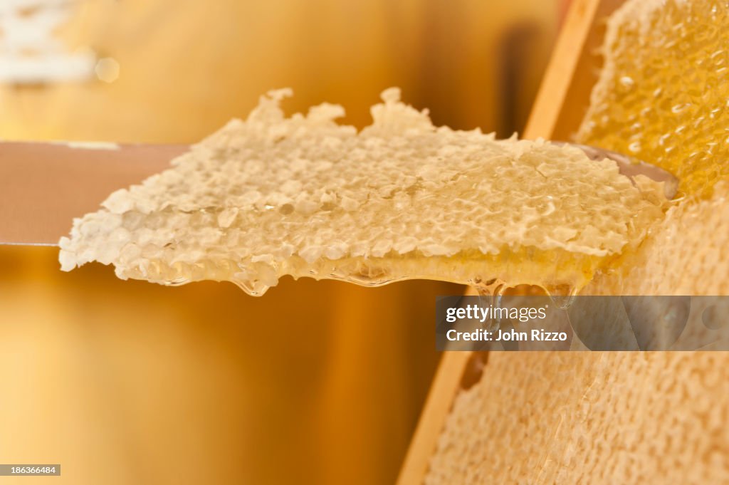 Close up of knife cutting honeycomb