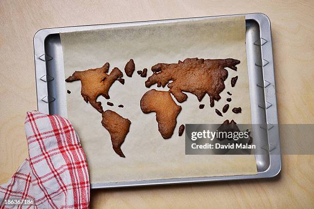 burnt cookies shaped like a world map - burnt cookies stock-fotos und bilder