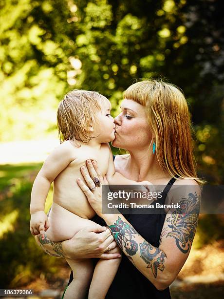 toddler daughter being kissed and held by mother - legacycollection stock pictures, royalty-free photos & images