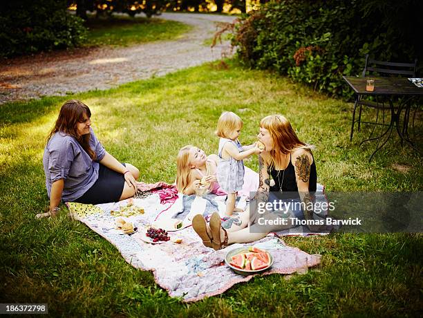 toddler feeding mom sandwich outdoors - toddler eating sandwich stock-fotos und bilder