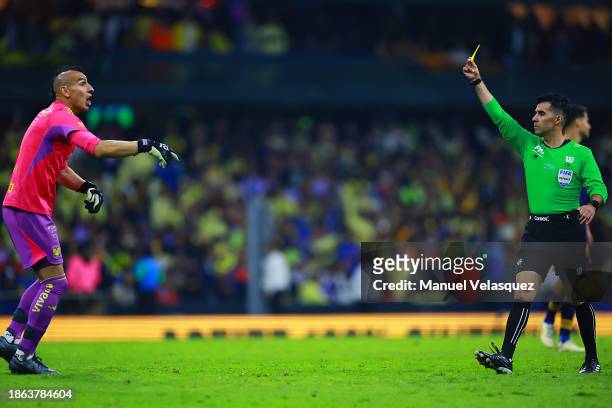 Referee Adonai Escobedo shows the second yellow card to Nahuel Guzman goalkeeper of Tigres UANL during the final second leg match between America and...