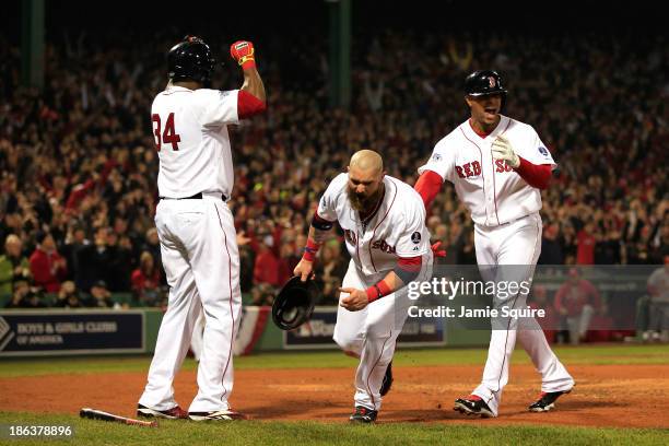 Jonny Gomes and David Ortiz of the Boston Red Sox celebrate after scoring in the third inning on a hit by Shane Victorino with Xander Bogaerts...