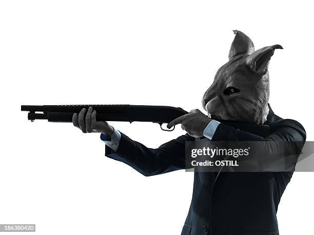 man wearing rabbit mask hunting with shotgun silhouette portrait